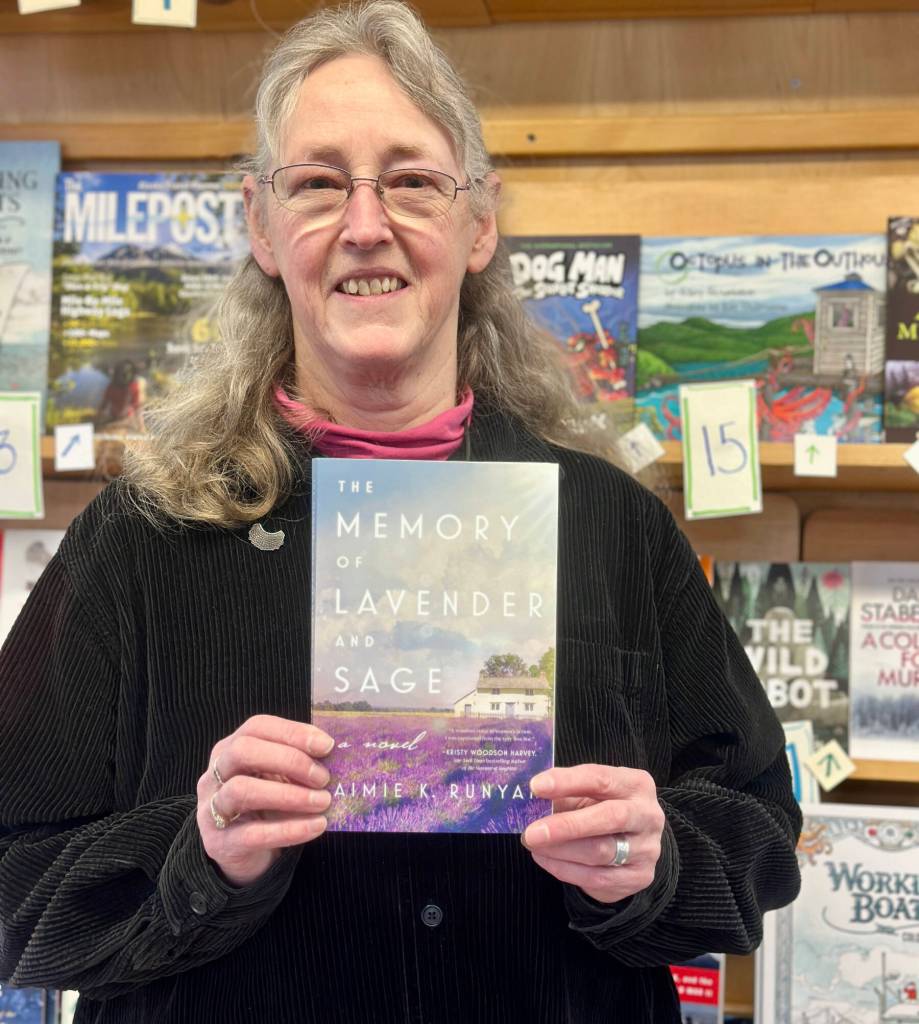 Homer Bookstore partner Sue Post poses with one of her favorite reads from 2024, which is also #7 on the Homer Bookstore Bestsellers List, on Monday, Jan. 20, 2025, in Homer, Alaska. Photo by Christina Whiting