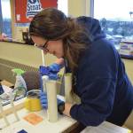 Amy Woodruff demonstrates an example of how to properly caulk a seam at the Homer Energy Fair on Saturday, Jan. 25. She said she was inspired to learn DIY home efficiency improvements when she became a homeowner. (Chloe Pleznac/Homer News)