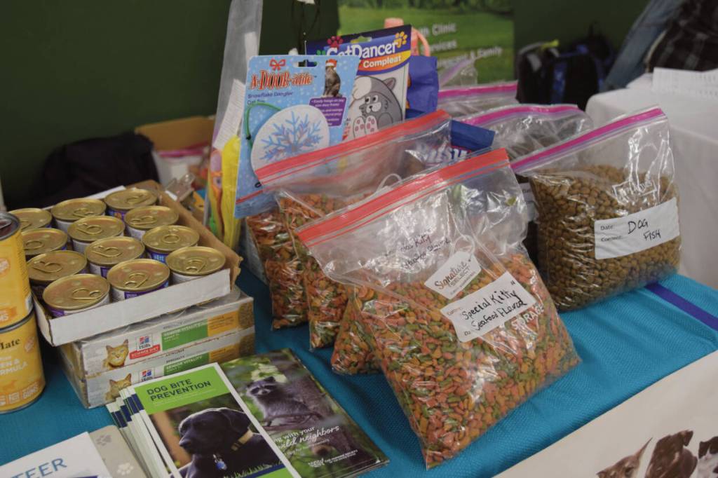 Bags of dog and cat food, toys, and resources are provided by the local animal shelter, Alaska Mindful Paws, at the annual Community Resource Connect event at the SPARC building in Homer, Alaska on Jan. 28, 2025. (Chloe Pleznac/Homer News)