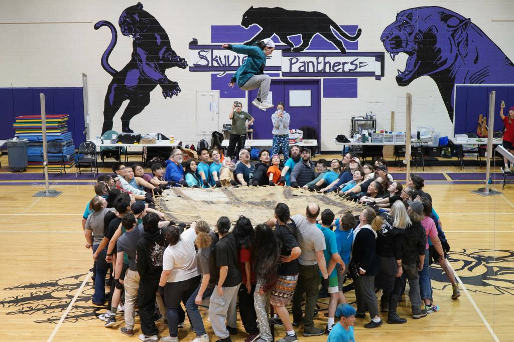 More than 50 people work together to perform a traditional blanket toss during the Kahtnuhtana Hey Chiula Native Youth Olympics Invitational at Skyview Middle School near Soldotna, Alaska, on Sunday, Jan. 26, 2025. (Jake Dye/Peninsula Clarion)