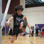 An athlete leaps up to perform the one-foot high kick during the Kahtnuhtana Hey Chiula Native Youth Olympics Invitational at Skyview Middle School near Soldotna, Alaska, on Sunday, Jan. 26, 2025. (Jake Dye/Peninsula Clarion)