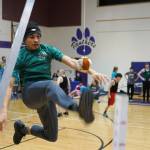An athlete leaps up to perform the one-foot high kick during the Kahtnuhtana Hey Chiula Native Youth Olympics Invitational at Skyview Middle School near Soldotna, Alaska, on Sunday, Jan. 26, 2025. (Jake Dye/Peninsula Clarion)