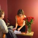 Co-owner Susannah Webster (right) checks in another attendee of The Porcupine Theaters grand reopening gala on Friday, Jan. 31, 2025, in Homer, Alaska. (Delcenia Cosman/Homer News)
