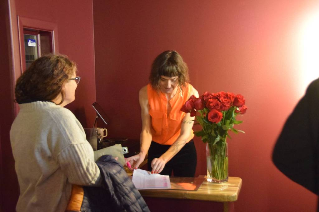 Co-owner Susannah Webster (right) checks in another attendee of The Porcupine Theaters grand reopening gala on Friday, Jan. 31, 2025, in Homer, Alaska. (Delcenia Cosman/Homer News)
