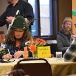 A volunteer judge (left) makes a note on a scorecard after sampling a drink during the annual Homer Brewfest, part of this years Winter Carnival Celebration, at the Best Western Bidarka Inn on Saturday, Feb. 8, 2025, in Homer, Alaska. (Chloe Pleznac/Homer News)