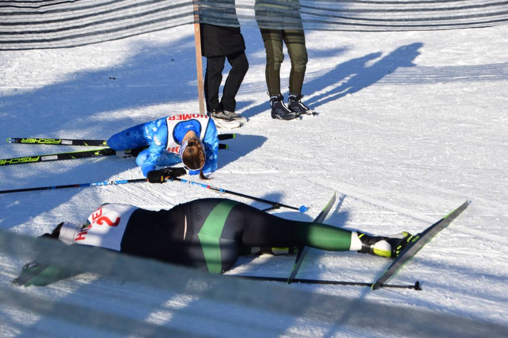 Soldotnas Tania Boonstra and Colonys Elliot Sensabaugh collapse in exhaustion and adrenaline at the finish line on Saturday, Feb. 8, 2025. The girls placed 1st and 2nd overall for the weekend, with Boonstra winning the title of girls Skimeister with an overall time 5 seconds faster than Sensabaugh. (Chloe Pleznac/Homer News)