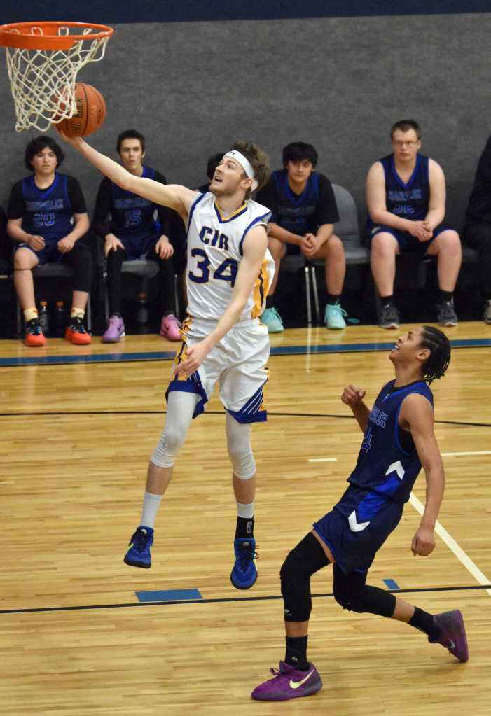 Zach Armstrong of Cook Inlet Academy drives against Marcarius Evans of Nanwalek on Saturday, February 15, 2025, at Cook Inlet Academy just outside of Soldotna, Alaska. (Photo by Jeff Helminiak/Peninsula Clarion)