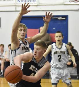 Nikiskis Kameron Bird is pressured by Ninilchiks Kade McCorison at the Keith Presley Memorial Tournament on Friday, February 14, 2025, at Ninilchik School in Ninilchik, Alaska. (Photo by Jeff Helminiak/Peninsula Clarion)