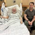 Dr. Lars Matkin sits with patient Michael Craig, post-surgery, in January at South Peninsula Hospital. The surgery marks the first time in recent years that a total hip replacement was done locally. (Photo courtesy of South Peninsula Hospital)