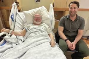 Dr. Lars Matkin sits with a happy patient post-surgery in January at South Peninsula Hospital. The surgery marks the first time in recent years that a hip replacement was done locally. (Photo courtesy of South Peninsula Hospital)