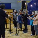 Nancy Chambers (left) leads the Chapman Eagle Ensemble, part of Homer OPUS, in playing Twinkle Twinkle Little Star during the Cabin Fever Variety Show on Thursday, Feb. 27, 2025, in the Chapman School gym as part of the 2025 Snow Rondi in Anchor Point, Alaska. (Delcenia Cosman/Homer News)