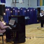 Chapman School first grade teacher Rachel Ostler (left) provides piano accompaniment to her mother, Cara Long, as she sings Bette Midlers The Rose during the Cabin Fever Variety Show on Thursday, Feb. 27, 2025, in the Chapman School gym as part of the 2025 Snow Rondi in Anchor Point, Alaska. (Delcenia Cosman/Homer News)