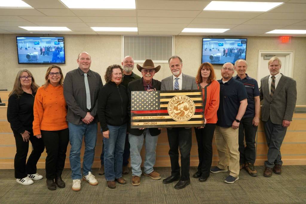 Retired Kachemak Emergency Services Chief Robert Cicciarella, center, is honored by the Kenai Peninsula Borough Assembly during their meeting in Soldotna, Alaska, on Tuesday, Feb. 25, 2025. (Jake Dye/Peninsula Clarion)