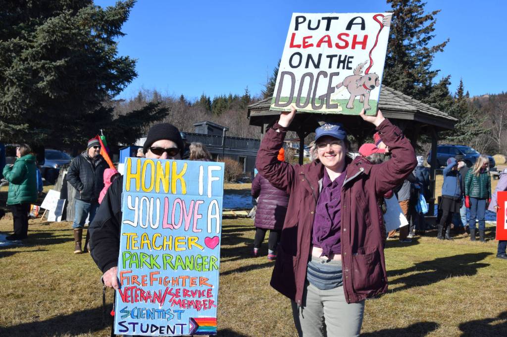 Community members hold up protest signs during the Stand for Democracy Rally on International Womens Day, March 8, 2025, at WKFL Park in Homer, Alaska. (Chloe Pleznac/Homer News)