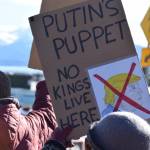 A community member holds up a protest sign during the Stand for Democracy Rally on International Womens Day, March 8, 2025 at WKFL Park in Homer, Alaska. (Chloe Pleznac/Homer News)