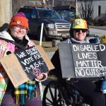 Community members hold up protest signs during the Stand for Democracy Rally on International Womens Day, March 8, 2025, at WKFL Park in Homer, Alaska. (Chloe Pleznac/Homer News)