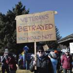 Robert Walsh stands with a protest sign at the Stand for Democracy Rally on International Womens Day, March 8, 2025, at WKFL Park in Homer, Alaska. (Chloe Pleznac/Homer News)
