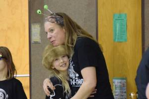 Teacher Jennifer Reinhart hugs Runa Larson as students file into the gymnasium before the Read-a-thon event on Feb. 28, 2025 at Paul Banks Elementary School in Homer, Alaska. (Chloe Pleznac/Homer News)