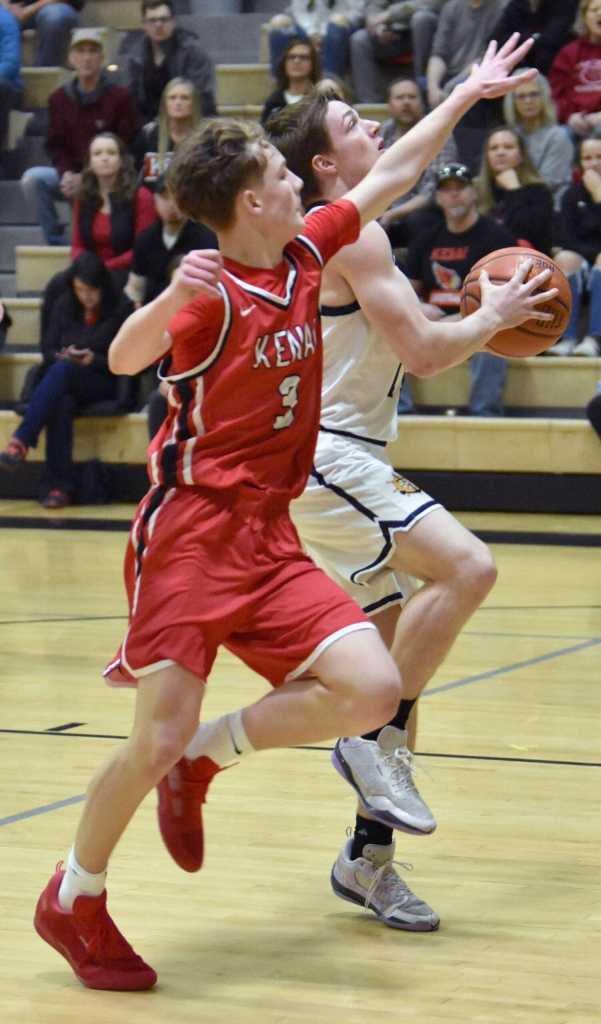 Homers Justus Grimes drives on Kenai Centrals Carter Felchle on Saturday, March 8, 2025, at the Peninsula Conference tournament at Nikiski Middle-High School in Nikiski, Alaska. (Photo by Jeff Helminiak/Peninsula Clarion)
