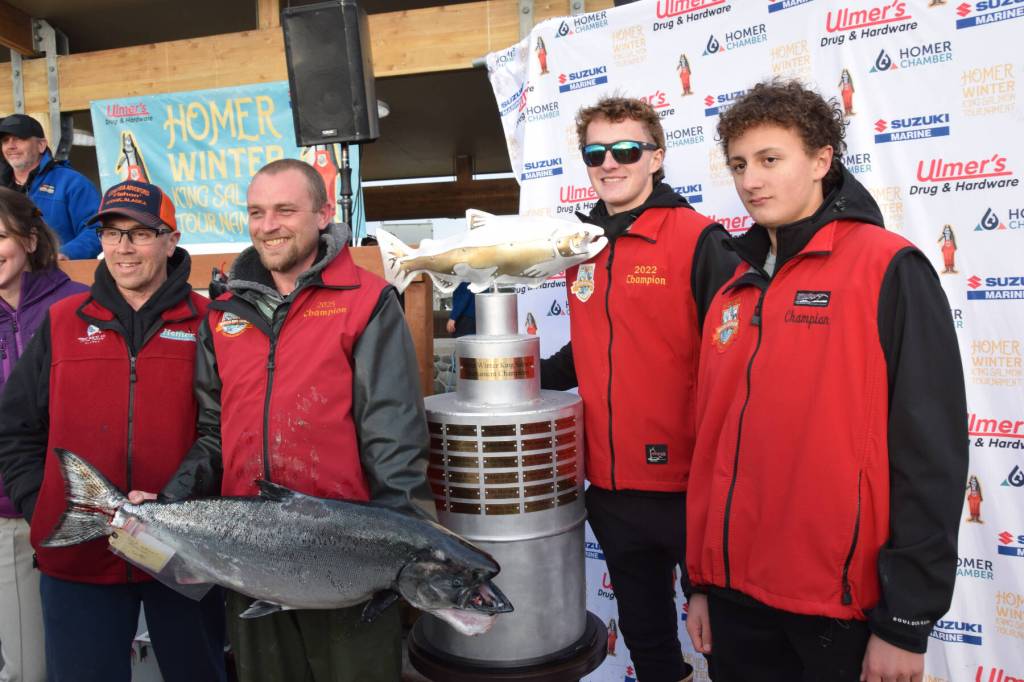 Zach Weimann (left center) poses with his prize-winning fish, previous tournament champions and the championship trophy during the 2025 Homer Winter King Salmon Tournament on Saturday, March 22, 2025, at the Deep Water Dock on the Homer Spit in Homer, Alaska. (Delcenia Cosman/Homer News)