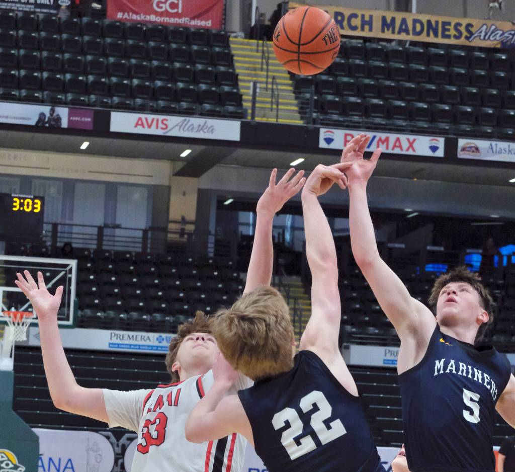 Kenais Mason Tunseth (33) and Homers Henry Wedvik (22) and Benjamin Engebretsen (5) reach for a tipped ball Thursday, March 20, 2025, in their consolation bracket semifinal during the 2025 ASAA March Madness Alaska 3A/4A Basketball State Championships at the Alaska Airlines Center in Anchorage, Alaska. (Klas Stolpe / Juneau Empire)