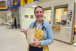 Vice Principal Katie Bynagle holds up a pitcher of pancake mix during the pancake breakfast on Tuesday, March 25, 2025 in the Homer High School commons. (Photo courtesy of Winter Marshall-Allen)