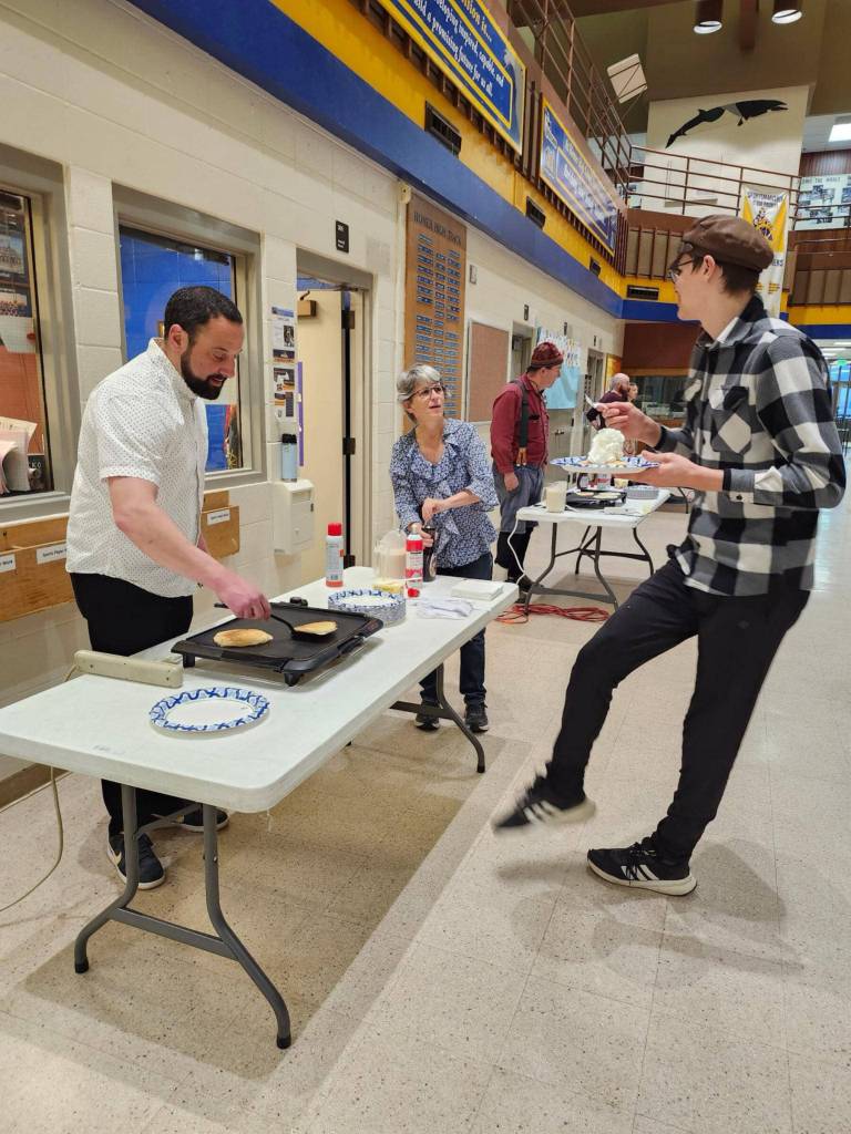 Counselor Paul Story flips pancakes for a student on Tuesday, March 25, 2025 in the Homer High School commons. (Photo courtesy of Winter Marshall-Allen)