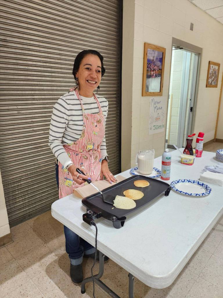 Teacher Winter Marshall-Allen flips pancakes for students on Tuesday, March 25, 2025 in the Homer High School commons. (Photo courtesy of Winter Marshall-Allen)