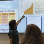 Kachemak Bay Conservation Society Vice President Penelope Haas points at a presentation slide on Homer housing data on Tuesday, March 25, 2025 at Kachemak Bay Campus. (Chloe Pleznac/Homer News)