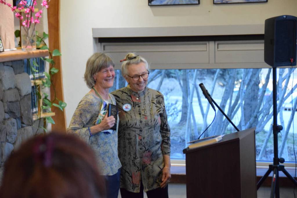 Awardee Carol Comfort-Waldorf, left, and Friends of the Homer Library President Joy Steward stand in front of the gathered crowd during the annual Celebration of Lifelong Learning event at the Homer Public Library on Saturday, March 29, 2025. Steward presented the award to Comfort-Waldorf. (Chloe Pleznac/Homer News)