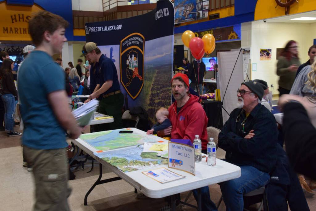 Captains Curtis Jackson and Mako Haggerty of Makos Water Taxi talk with a student on Friday, March 28, 2025 in the Homer High School commons. (Delcenia Cosman/Homer News)