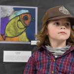 Student Raiden Dailey poses with his art on display at Paul Banks Elementary School during the annual Arts Extravaganza on Friday, April 4. (Chloe Pleznac/Homer News)