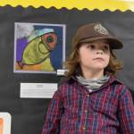 Student Raiden Dailey poses with his art on display at Paul Banks Elementary School during the annual Arts Extravaganza on Friday, April 4. (Chloe Pleznac/Homer News)