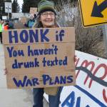 A protester holds up a sign during the nationwide Hands Off! protest on Saturday, April 5 at WKFL Park in Homer, Alaska. (Chloe Pleznac/Homer News)