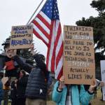 Protesters in Homer hold up signs during the nationwide Hands Off! protest on Saturday, April 5 at WKFL Park in Homer, Alaska. (Chloe Pleznac/Homer News)