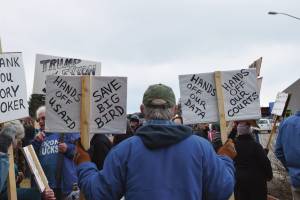 Chloe Pleznac/Homer News
A demonstrator in Homer holds up signs during the nationwide Hands Off! protest on Saturday, April 5, at WKFL Park in Homer.