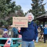 A protester holds up a sign during the nationwide Hands Off! protest on Saturday, April 5 at WKFL Park in Homer, Alaska. (Chloe Pleznac/Homer News)