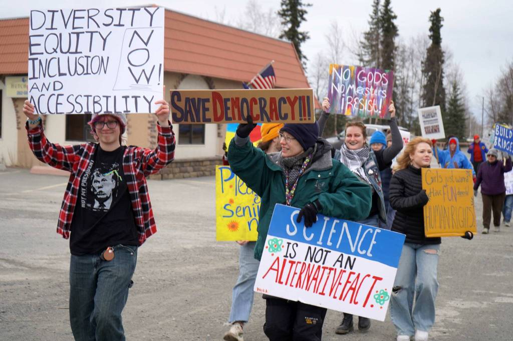 Protesters stand along the Sterling Highway in Soldotna, Alaska, participating in the Remove, Reverse, Reclaim protest organized by Many Voices and Kenai Peninsula Protests as part of the nationwide 50501 effort on Saturday, April 5, 2025. (Jake Dye/Peninsula Clarion)