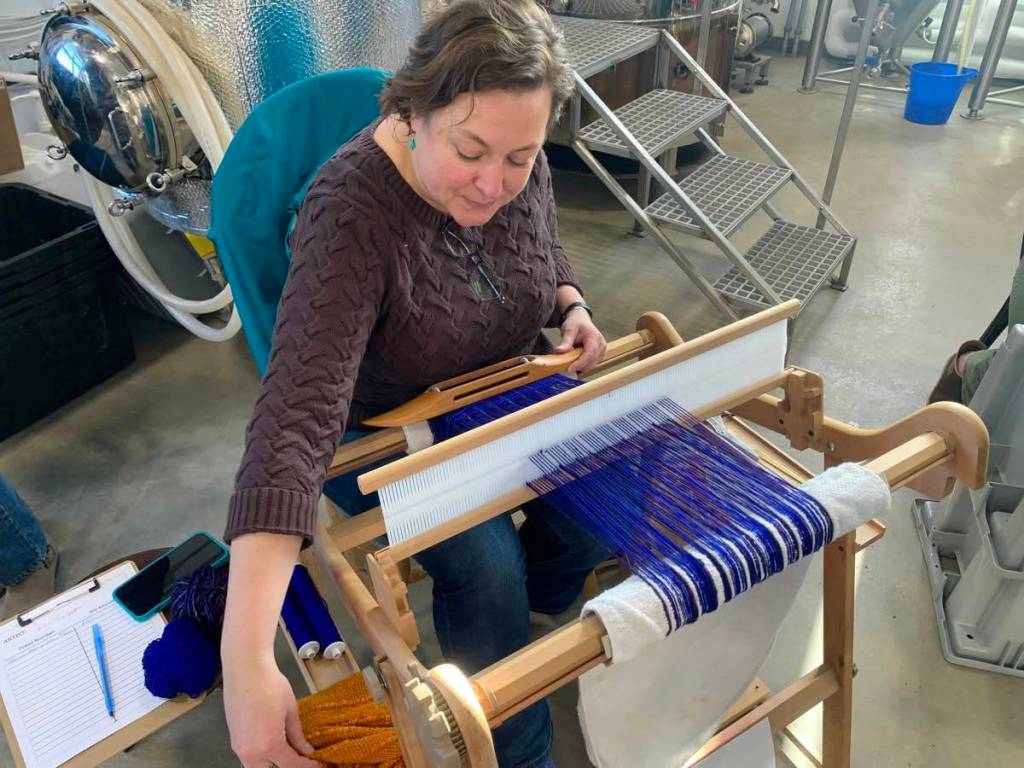 Homer weaver Lisa Talbott weaves a scarf during the 2023 Ready Set Art fundraiser at Grace Ridge Brewing. (Photo by Christina Whiting/Homer News)