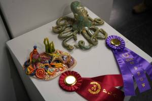 Octoparty, by Kenai Alternative High School student Adelynn DeHoyos, and Green Speckled Ocean, by Soldotna High School Student Savannah Yeager are seen as part of the 34th Annual Visual Feast Kenai Peninsula Borough School District Juried Student Art Show during an opening reception at the Kenai Art Center in Kenai, Alaska, on Friday, April 4, 2025. (Jake Dye/Peninsula Clarion)