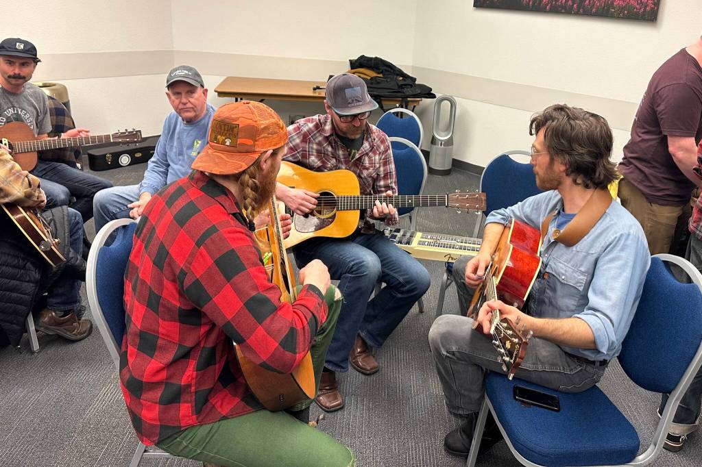 Guitar players compare notes during an instrument exchange Saturday at the 50th Alaska Folk Festival at Centennial Hall. (Mark Sabbatini / Juneau Empire)
