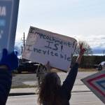 A protester throws a peace sign on Saturday, April 19 at WKFL Park during the Sustained Resistance, Makes a Difference Rally. (Chloe Pleznac/Homer News)