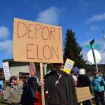 A protester stands with a sign that reads DEPORT ELON on Saturday, April 19 at WKFL Park during the Sustained Resistance, Makes a Difference Rally. (Chloe Pleznac/Homer News)