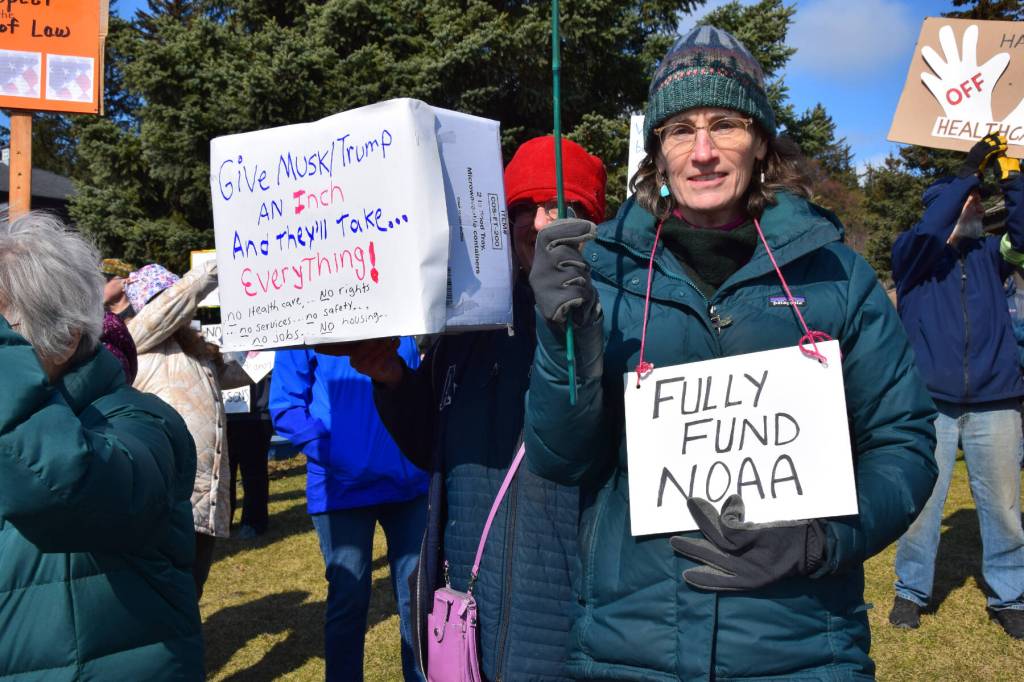 A protestor stands with a sign that reads FULLY FUND NOAA on Saturday, April 19 at WKFL Park during the Sustained Resistence, Makes a Difference Rally. (Chloe Pleznac/Homer News)