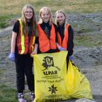 HoWLers Quinn Blackstock, Arwyn Linder, and Eden Fox (left to right) pick up trash around town during the annual DiRtBaG Clean-Up Week on Monday, April 21, 2025, in Homer, Alaska. Since 2011, 900 DiRtBaGs have cleaned up 1720 bags of litter from Homers trails, beaches, streets and sidewalks. (Chloe Pleznac/Homer News)