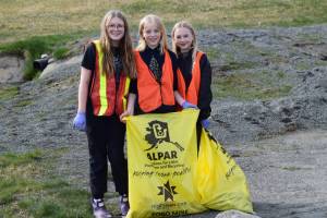HoWLers Quinn Blackstock, Arwyn Linder, and Eden Fox (left to right) pick up trash around town during the annual DiRtBaG Clean-Up Week on Monday, April 21, 2025, in Homer, Alaska. Since 2011, 900 DiRtBaGs have cleaned up 1720 bags of litter from Homers trails, beaches, streets and sidewalks. (Chloe Pleznac/Homer News)