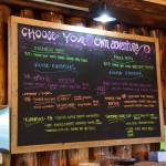 A deli board hangs with a selection of food options in the Fritz Creek General Store on its reopening day on Thursday, April 24. (Chloe Pleznac/Homer News)