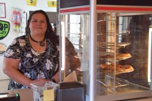 P.K. stands by the much-missed pizza hot case in the Fritz Creek General Store on its reopening day on Thursday, April 24. (Chloe Pleznac/Homer News)