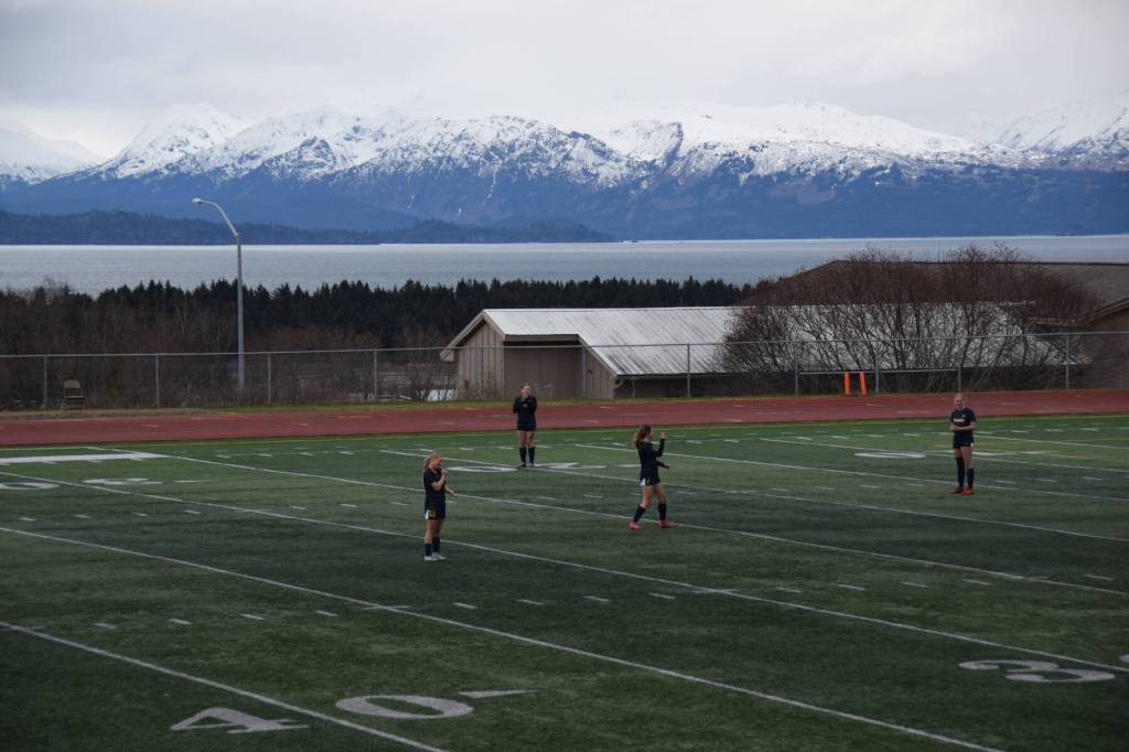 Homer players await the start of the first game of the day at the Homer High School athletic field on April 26. (Chloe Pleznac/Homer News)