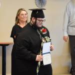 Kiprian Reutov holds up his diploma during the Voznesenka School commencement ceremony held Monday, May 19, 2025, at Lands End Resort in Homer, Alaska. (Delcenia Cosman/Homer News)
